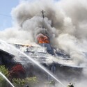 Firefighters spray water onto the roof of St. Catherine of Siena Catholic Church